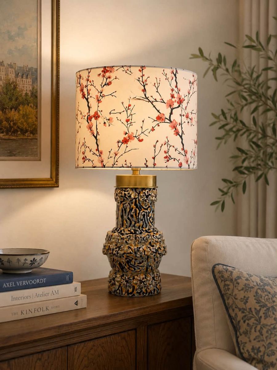 A Lamparita lamp with a cherry-blossom shade, lit on a wooden sideboard